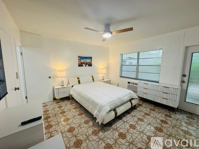 A bedroom with a bed, a ceiling fan, and a window with blinds.