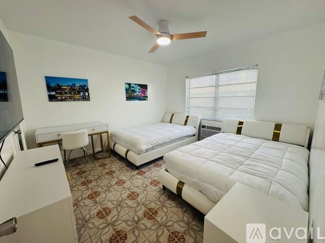 A bedroom with two beds and a ceiling fan.