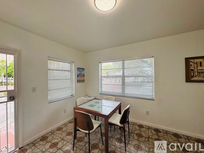 A dining room with a table and chairs.