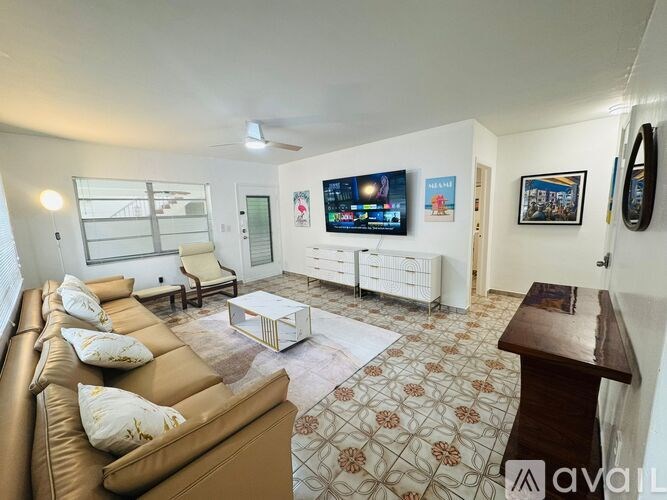 A living room with a couch, a coffee table, and a television.