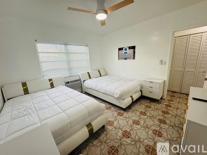 A bedroom with two beds and a ceiling fan.
