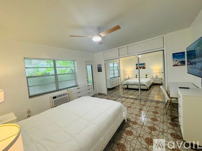 A bedroom with a large bed and a ceiling fan.