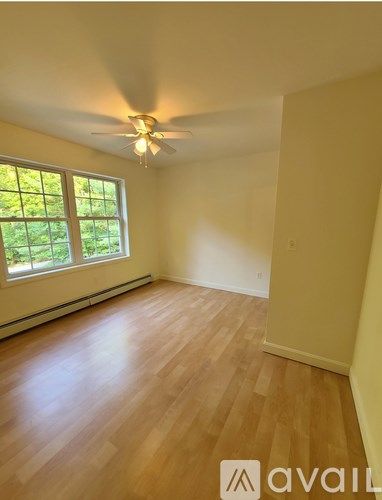 A room with wooden flooring and a ceiling fan.