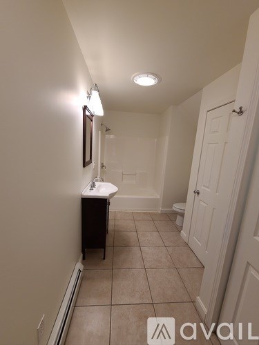 A bathroom with a toilet, sink, and a white door.