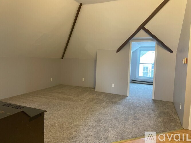 A room with a carpeted floor and a door leading to a balcony.