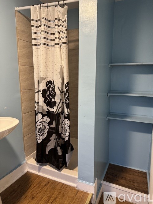 A shower curtain with a floral pattern hangs in a bathroom.