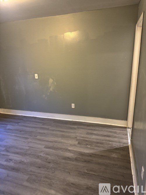 A room with grey walls and a wooden floor.