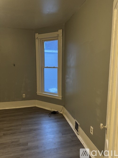 A room with a window and wooden floors.