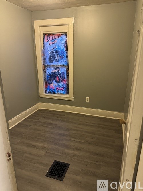 A room with a poster on the wall and a drain in the floor.