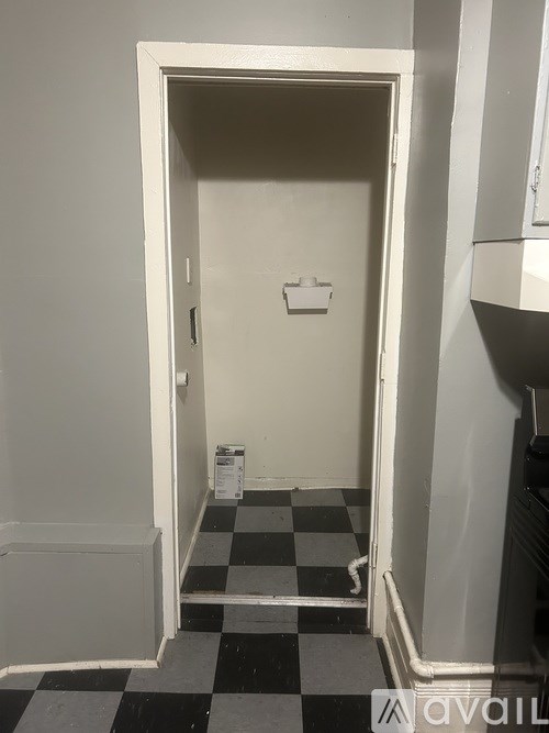 A white door with a black and white checkered floor.