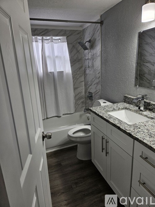 A bathroom with a toilet, sink, and shower.