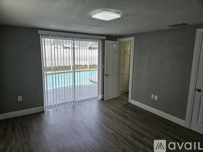 A room with a sliding glass door leading to a pool.