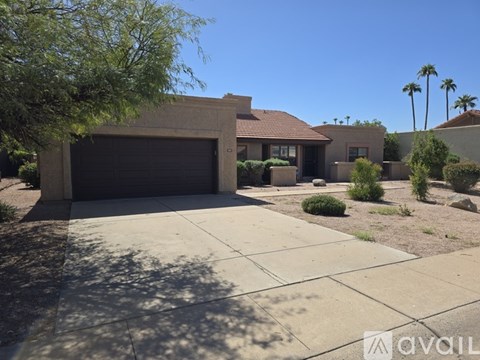 A house with a garage and a driveway in front of it.
