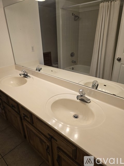 A bathroom with two sinks and a large mirror.