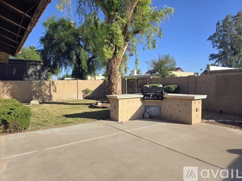 A concrete patio with a tree and a concrete structure in the middle.