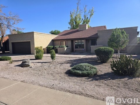 A house with a brown roof and a driveway in front.