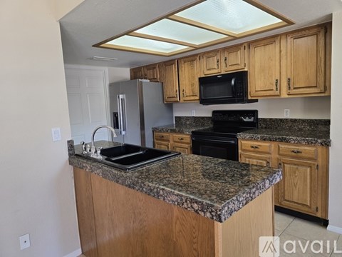 A kitchen with granite countertops and wooden cabinets.