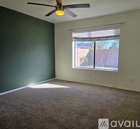 A room with a ceiling fan and carpeted floor.