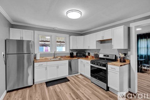 A modern kitchen with white cabinets and stainless steel appliances.
