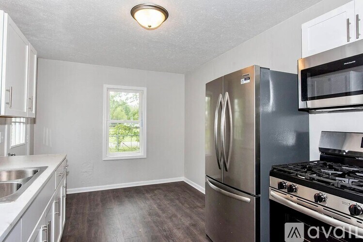 A kitchen with a stainless steel refrigerator, microwave, and oven.