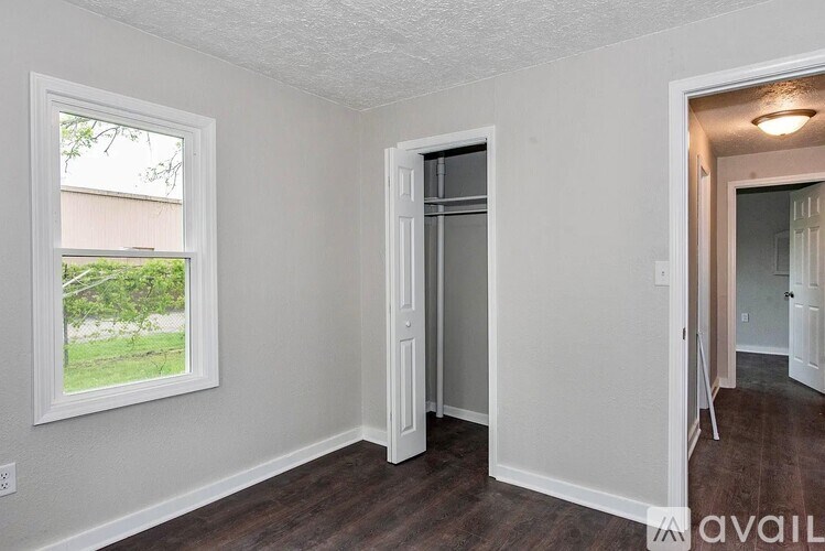 A room with a window and a door leading to another room.