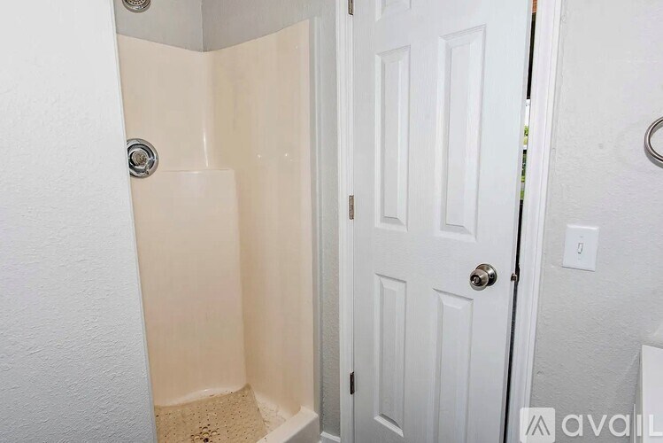 A white door with a silver handle is next to a white wall.