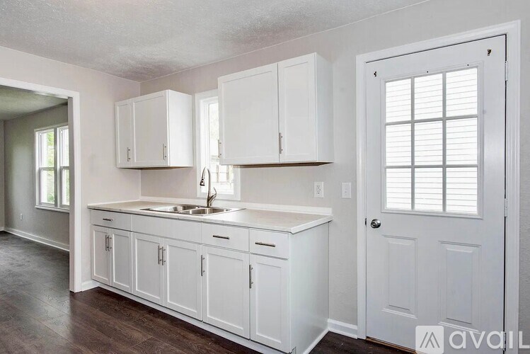 A kitchen with white cabinets and a sink.