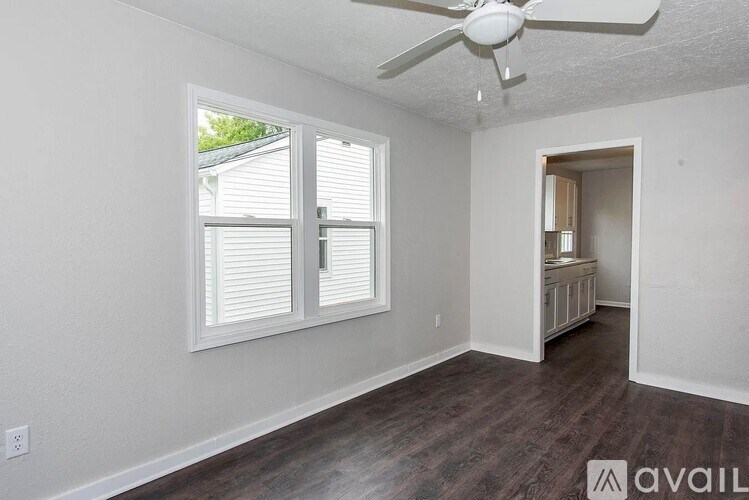 A room with a ceiling fan and a window with blinds.