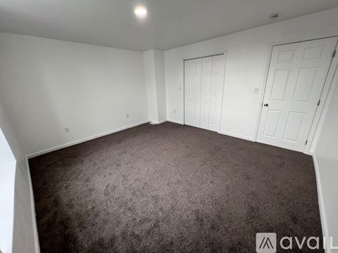 A room with brown carpet and white walls.