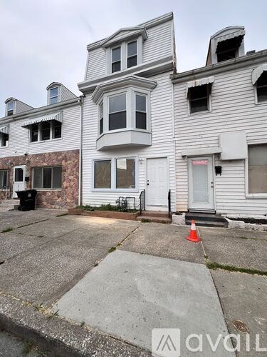 A house with a grey facade and a white door is shown.