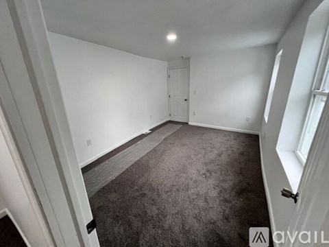 A room with a carpeted floor and white walls.