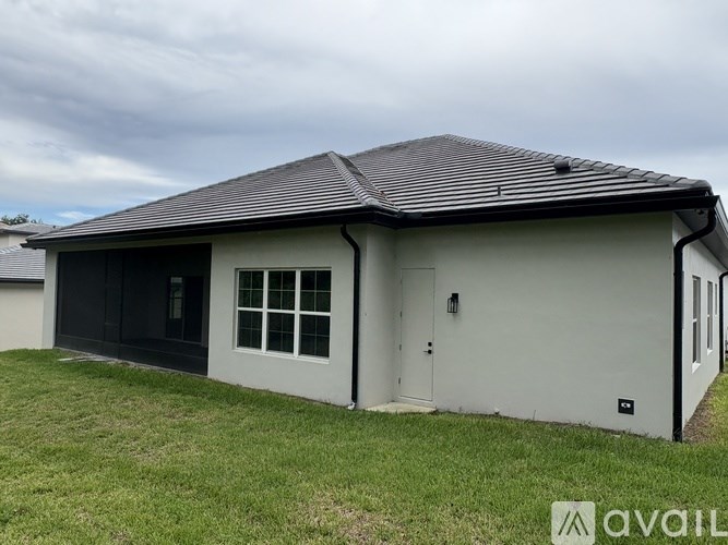 A house with a grey roof and white walls is available for rent.