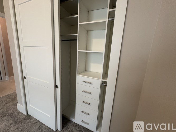 A white wardrobe with shelves and drawers is open.