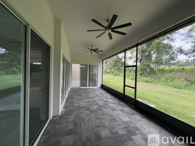 A long hallway with a ceiling fan and sliding glass doors.