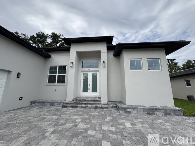 A modern house with a grey front yard.