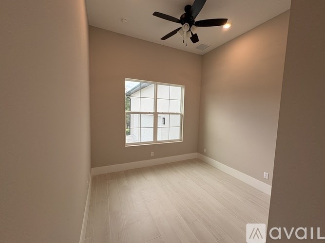 A room with a ceiling fan and a window.