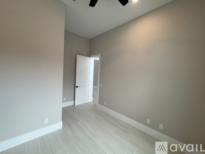 A room with a door and a ceiling fan.