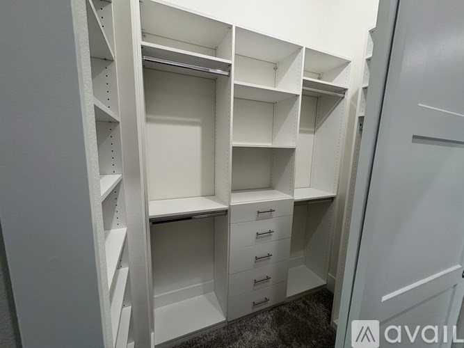 A white walk-in closet with shelves and drawers.
