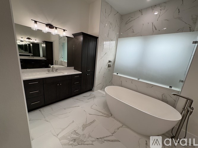 A bathroom with a marble floor and a white bathtub.