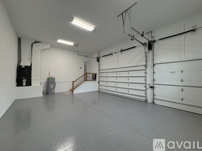 A spacious garage with a grey floor and white walls.