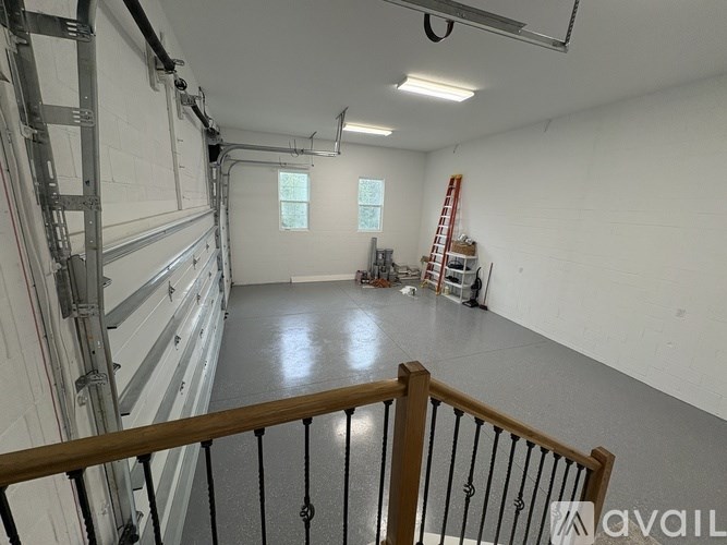 A spacious room with a ladder and some construction materials.