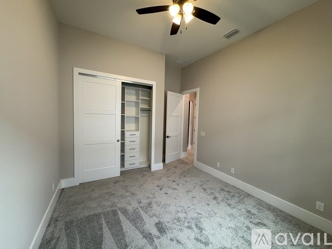 A room with a ceiling fan and a carpeted floor.