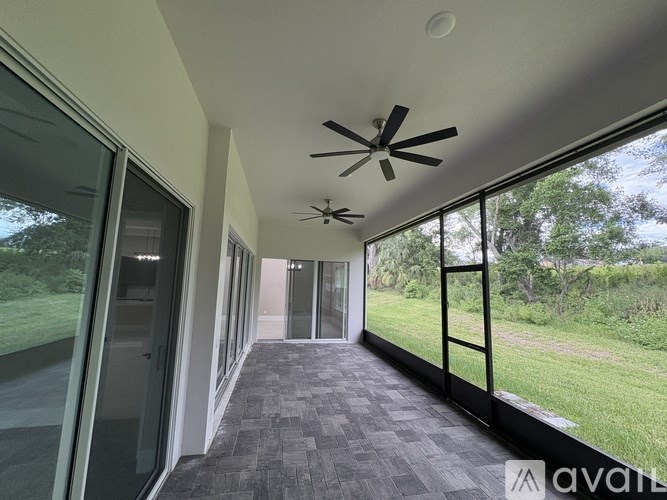 A long hallway with a ceiling fan and sliding glass doors.