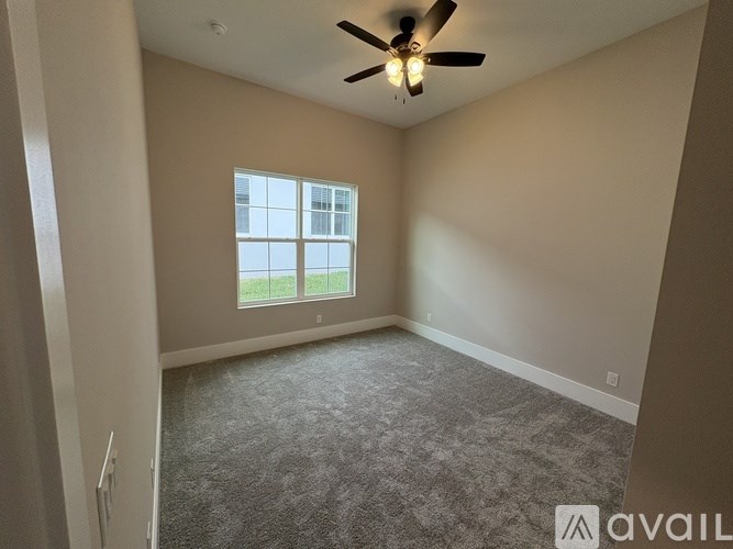 A room with a ceiling fan and a window.
