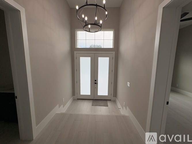 A modern interior with a chandelier and a large window.