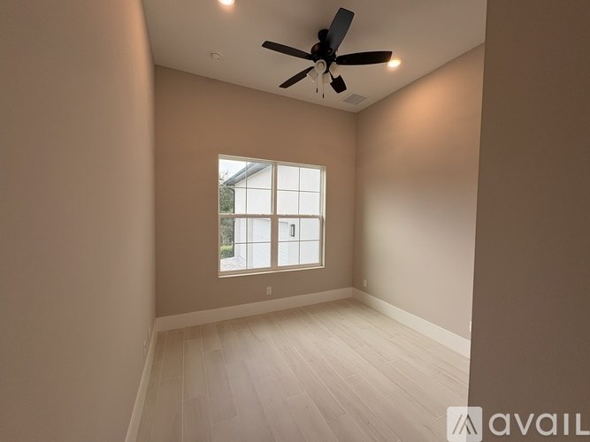 A room with a ceiling fan and a window.