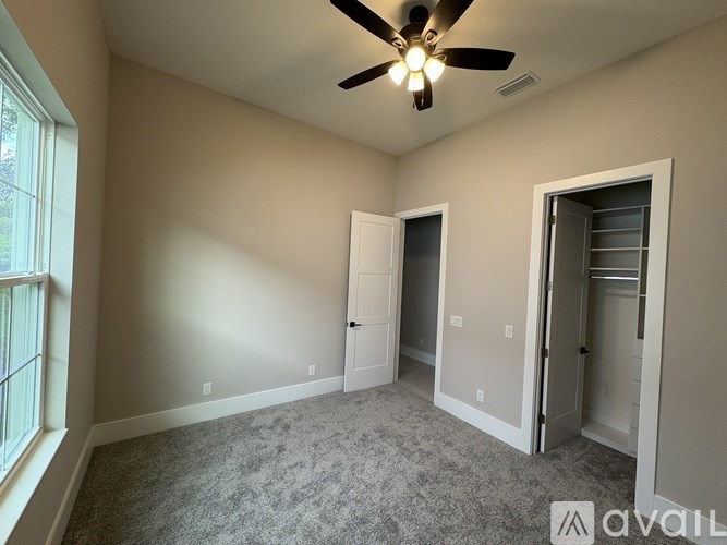 A room with a ceiling fan and two doors.