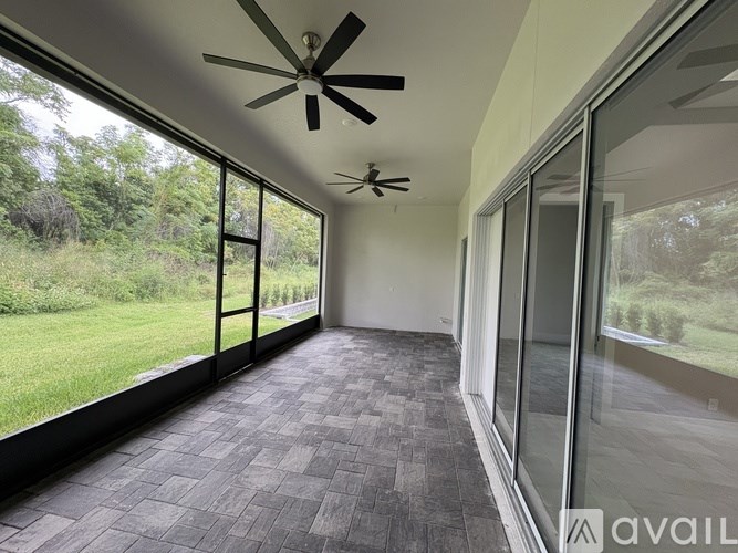 A room with a ceiling fan and sliding glass doors.