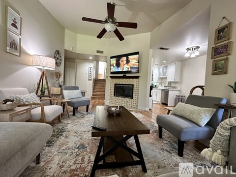 A living room with a fireplace and a television on the wall.