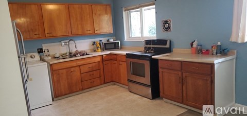 A kitchen with wooden cabinets and a white fridge.